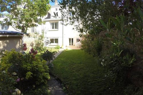 a white house with a garden in front of it at IDEAL - Plage, jardin & jacuzzi, proche plage et thalasso - 1 à 6 personnes in Saint Malo