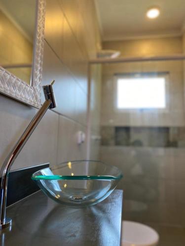 a glass bowl sitting on a counter in a bathroom at TBS Prime Suítes in São Sebastião