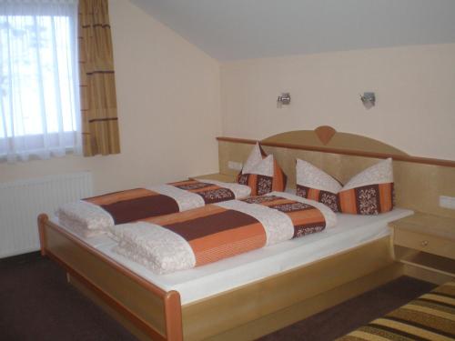 a bedroom with a large bed with orange and brown pillows at Apart Stella Bianca in Kappl