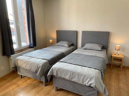 twee bedden naast elkaar in een slaapkamer bij Appartement au Centre de Stavelot in Stavelot