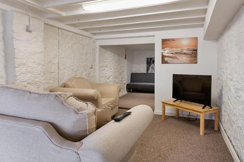 a living room with a couch and a tv at Alexandra Cottage Comfortable Apt near Swansea & M4 in Swansea