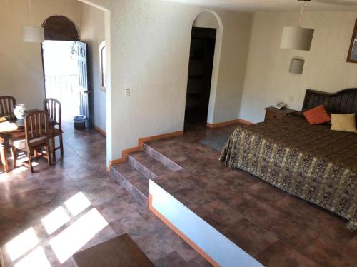 a bedroom with a bed and a dining room with a table at Casa Grande in Zacatlán