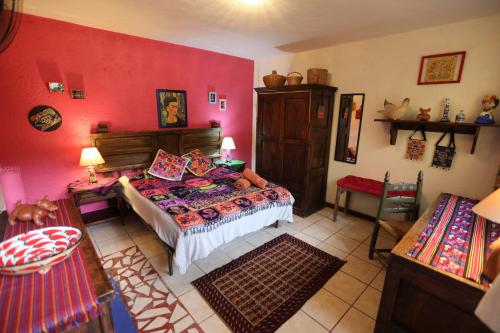 a bedroom with a bed and a red wall at Frida by Majikal B&B in Cholula