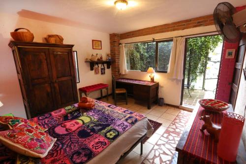 a room with a bed and a desk and a window at Majikal B&B - Frida in Cholula