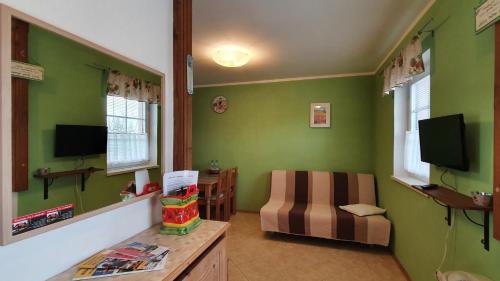 a living room with green walls and a chair at Penzion Na Lednické in Hlohovec