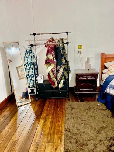 a bedroom with a bed and a dresser and a mirror at Blue Door Housing Historic Quito in Quito
