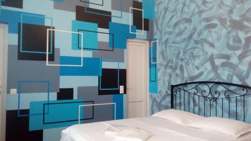 ein Schlafzimmer mit einem Bett mit einer blauen und schwarzen Wand in der Unterkunft Hotel Isani in Tbilisi City