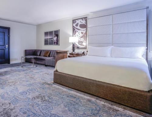 a bedroom with a large bed and a couch at Hotel Amarano Burbank-Hollywood in Burbank