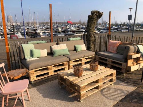 un sofá y una mesa de centro frente a un puerto deportivo en Bed and Breakfast De Biesbosch - in 't Riet, en Drimmelen