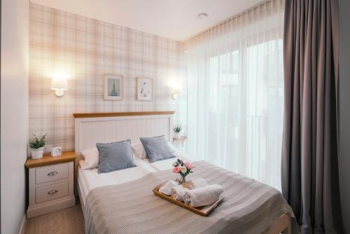 a bedroom with a bed with a vase of flowers on it at J14A I Rooms & Apartments AUTOMATED SELF CHECK-IN in Vilnius