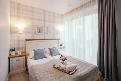 a bedroom with a bed with a vase of flowers on it at Real House Jasinskio WEB-APP SELF CHECK-IN in Vilnius