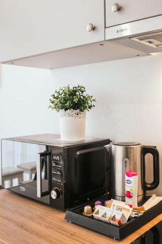 a microwave on a kitchen counter with a plate of food at J14A I Rooms & Apartments AUTOMATED SELF CHECK-IN in Vilnius