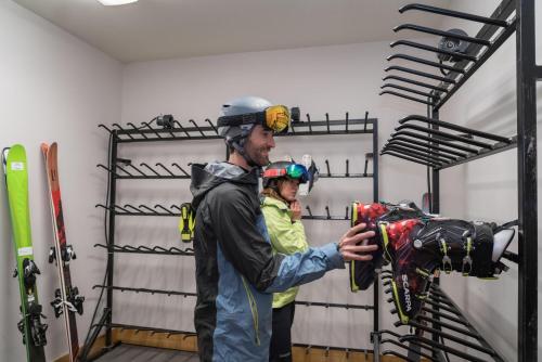 a man and a woman standing in a room with skis at Bear Creek Lodge in Telluride