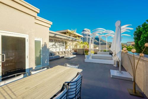 a patio with a wooden table and chairs and a building at Hotel Amarano Burbank-Hollywood in Burbank