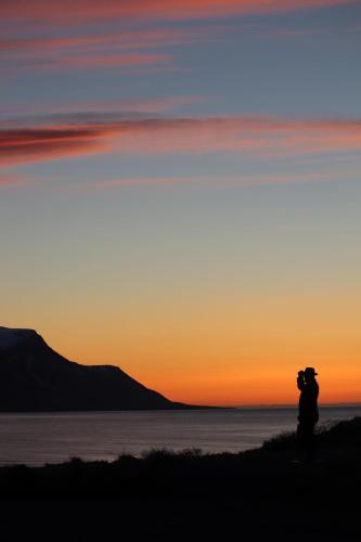 a person taking a picture of the sunset at Hlín Guesthouse in Varmahlid