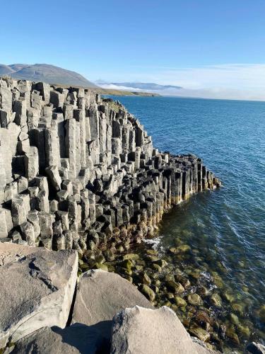 a stone wall in the ocean next to the water at Hlín Guesthouse in Varmahlid
