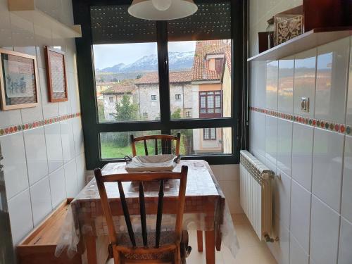 a kitchen with a table and two chairs and a window at Babilonia, apartamento en Llanes tranquilo y céntrico a 150m de la playa del Sablón in Llanes