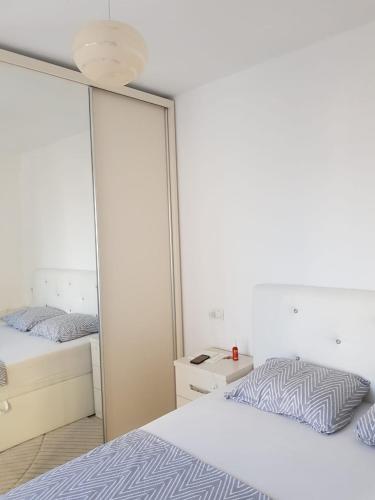 a bedroom with two beds and a mirror at Sole Inn in Durrës