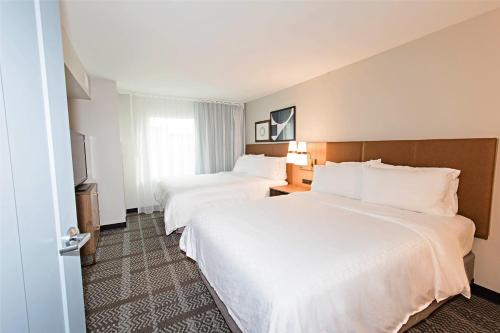 a hotel room with two beds and a window at Staybridge Suites - Denver North - Thornton by IHG in Thornton
