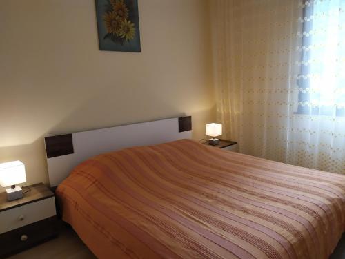 a bedroom with a bed and two night stands with lamps at Hiša Belin in Podbela