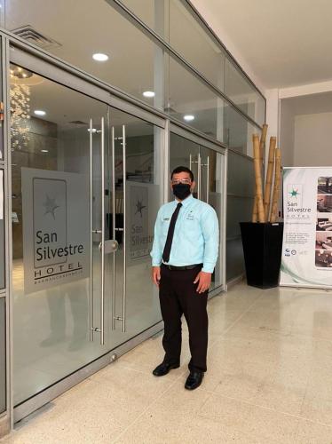 a man wearing a mask standing in front of a store at Hotel San Silvestre in Barrancabermeja