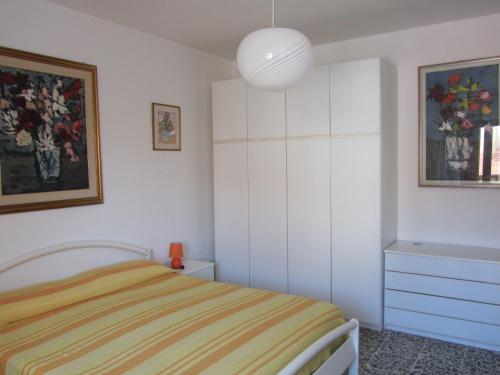 a white bedroom with a bed and a painting at Al Martin Pescatore in Stintino