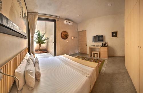 a bedroom with a large white bed in a room at Casa Carmen Reforma in Oaxaca City