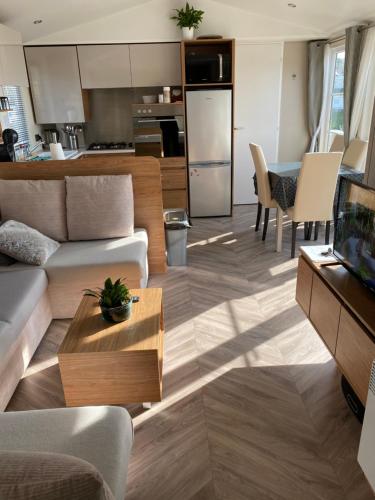 uma sala de estar com um sofá e uma mesa em camping de la falaise à equihen plage em Équihen-Plage