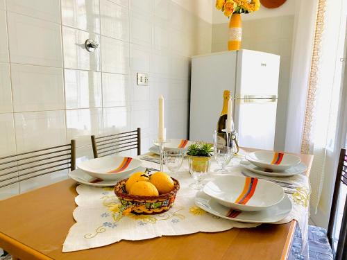 a dining table with plates and a basket of fruit on it at Ca del Mare - FREE Parking in La Spezia