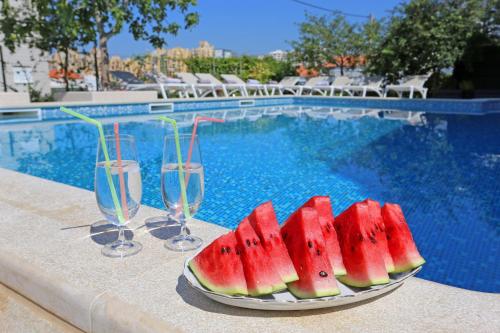 a plate of watermelon slices on a table next to a swimming pool at Villa Žnjan in Split