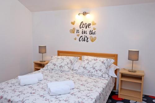 a bedroom with a bed with a sign that reads love is in the air at Villa Žnjan in Split