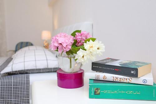 a table with books and a vase with flowers on it at Villa Žnjan in Split