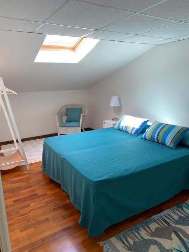 a bedroom with a large blue bed and a chair at Enea al mare in Cinquale