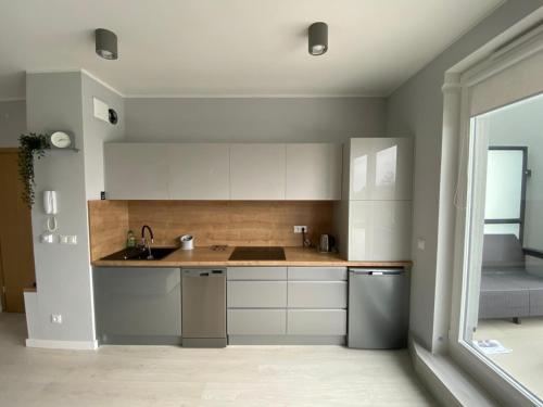 a kitchen with white cabinets and a sink at Apartament w Słonecznej Dolinie Jastrzębia Góra in Jastrzębia Góra