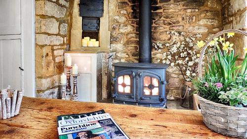 a book sitting on a table with a fireplace at Magnolia Cottage in Moreton in Marsh