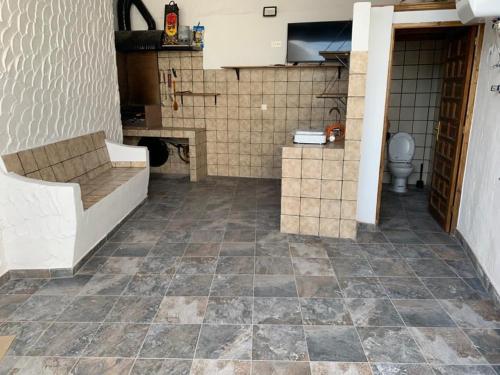 a bathroom with a toilet and a tiled floor at Casa Juani in Las Palmas de Gran Canaria