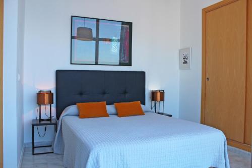 1 dormitorio con 1 cama con 2 almohadas de color naranja en Apartamento de Lujo con terraza privada y vistas al mar en Torre Lúgano, en Benidorm