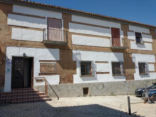 a brick building with a door and stairs on it at La Casona de la Luz in Guadix
