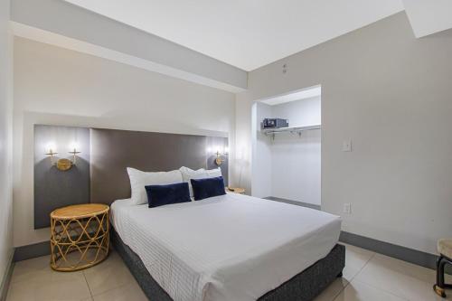 Un dormitorio con una gran cama blanca con almohadas azules. en Roami at Habitat Brickell, en Miami
