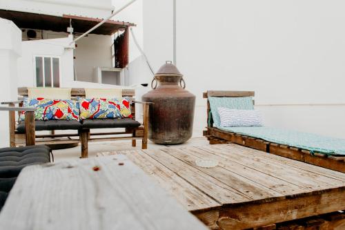 eine Terrasse mit 2 Stühlen und einem Holztisch in der Unterkunft Residencial Avenida in Faro