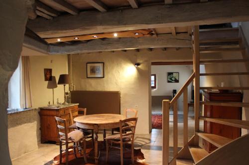 una sala da pranzo con tavolo e sedie in legno di Auberge du Val d'Aisne a Fanzel