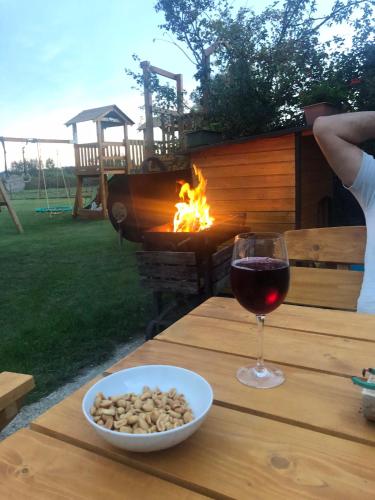 a glass of wine and a bowl of nuts on a table at KARÁM Vendégház és Lakásétterem in Nagybajcs