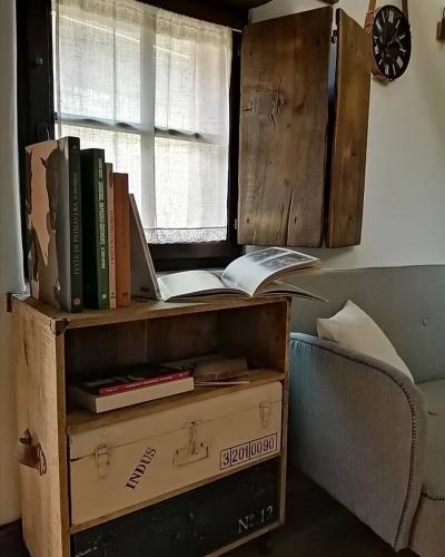 a book shelf with books and a laptop on it at B&B e Home Restaurant S'ispera Monolocale uso esclusivo in Fonni