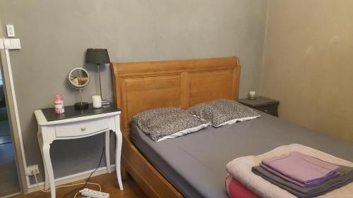 a bedroom with a bed and a nightstand with a mirror at Appartement F3 in Besançon