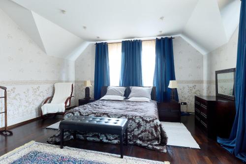 a bedroom with a bed with blue drapes at Villa de Jardin in Svyatopetrivske