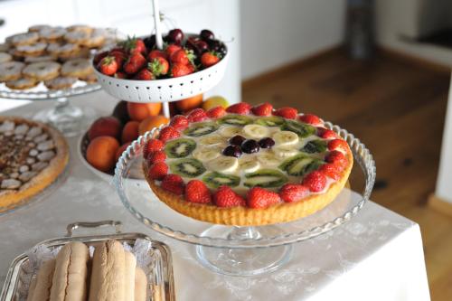a table topped with a cake with fruit on top at B&B e Home Restaurant S'ispera Monolocale uso esclusivo in Fonni