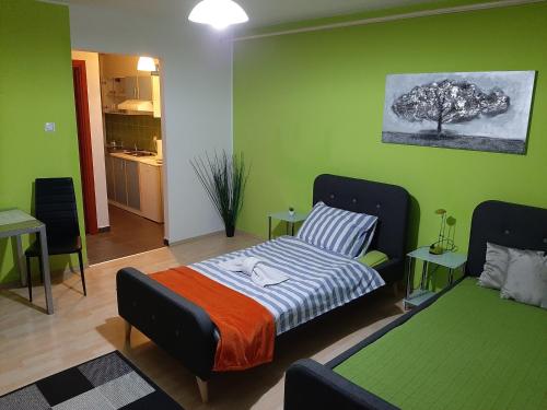 1 dormitorio con cama y pared verde en Apartmani Arena Zagreb, en Zagreb