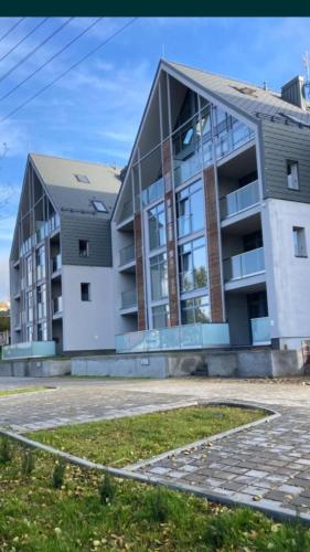 a large white building with a lot of windows at Nowoczesny Apartament z widokiem na jezioro in Charzykowy