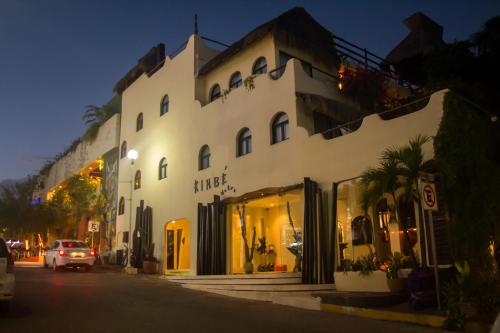 a white building on the side of a street at Kinbe Hotel Boutique in Playa del Carmen