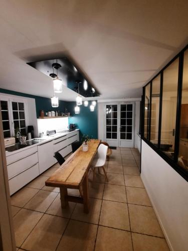 - une cuisine avec une table en bois dans une chambre dans l'établissement la longère charmante, à Céaux